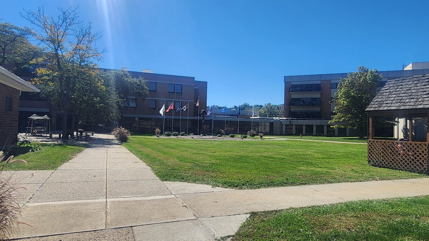 Courtyard at the Indiana Veterans Home with Mitchell Hall and military branch flags visible in the background