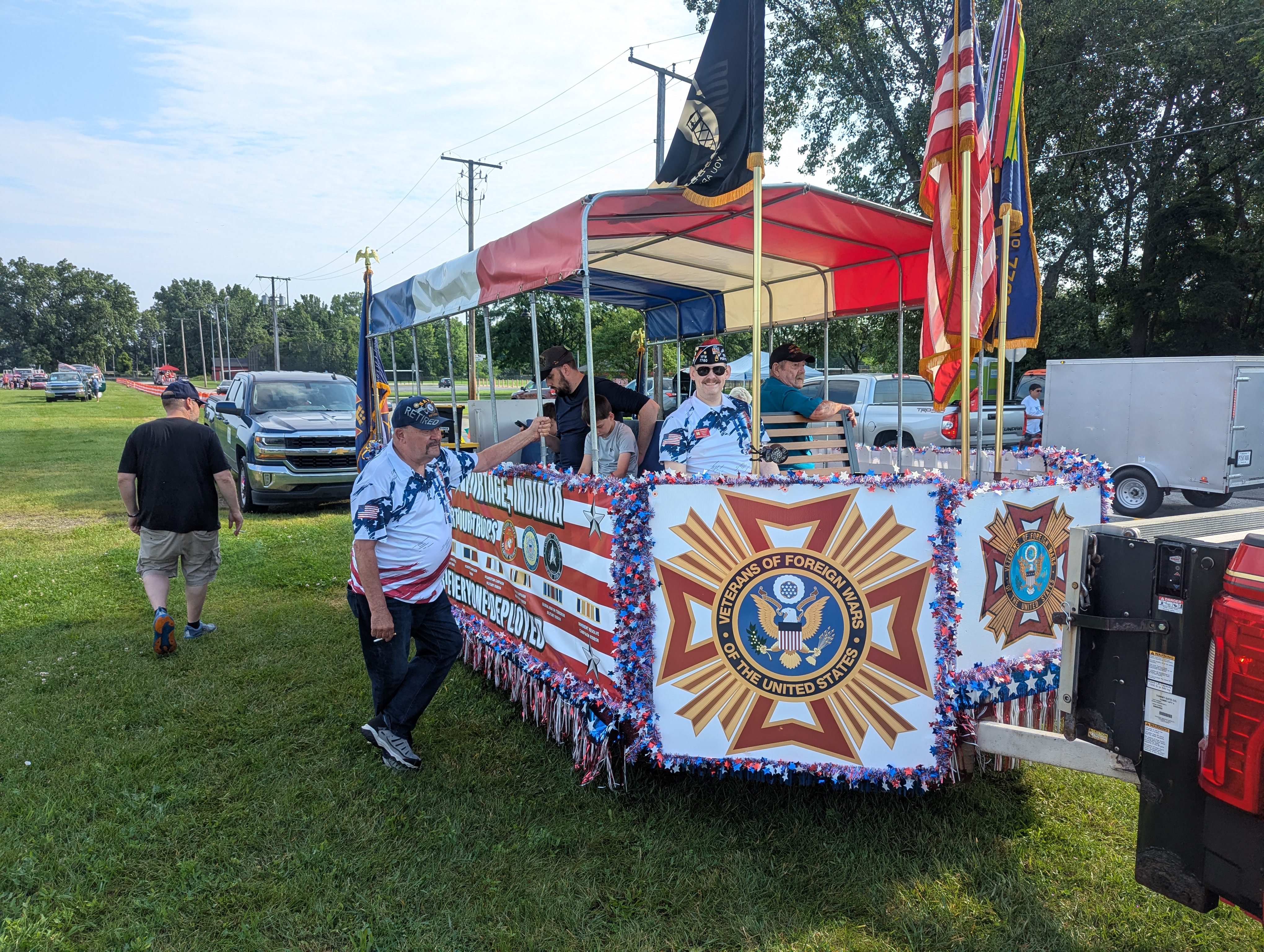 VFW Post 7760 parade float decorated with the VFW seal, red, white and blue fringe, and American flags at the Portage 4th of July parade