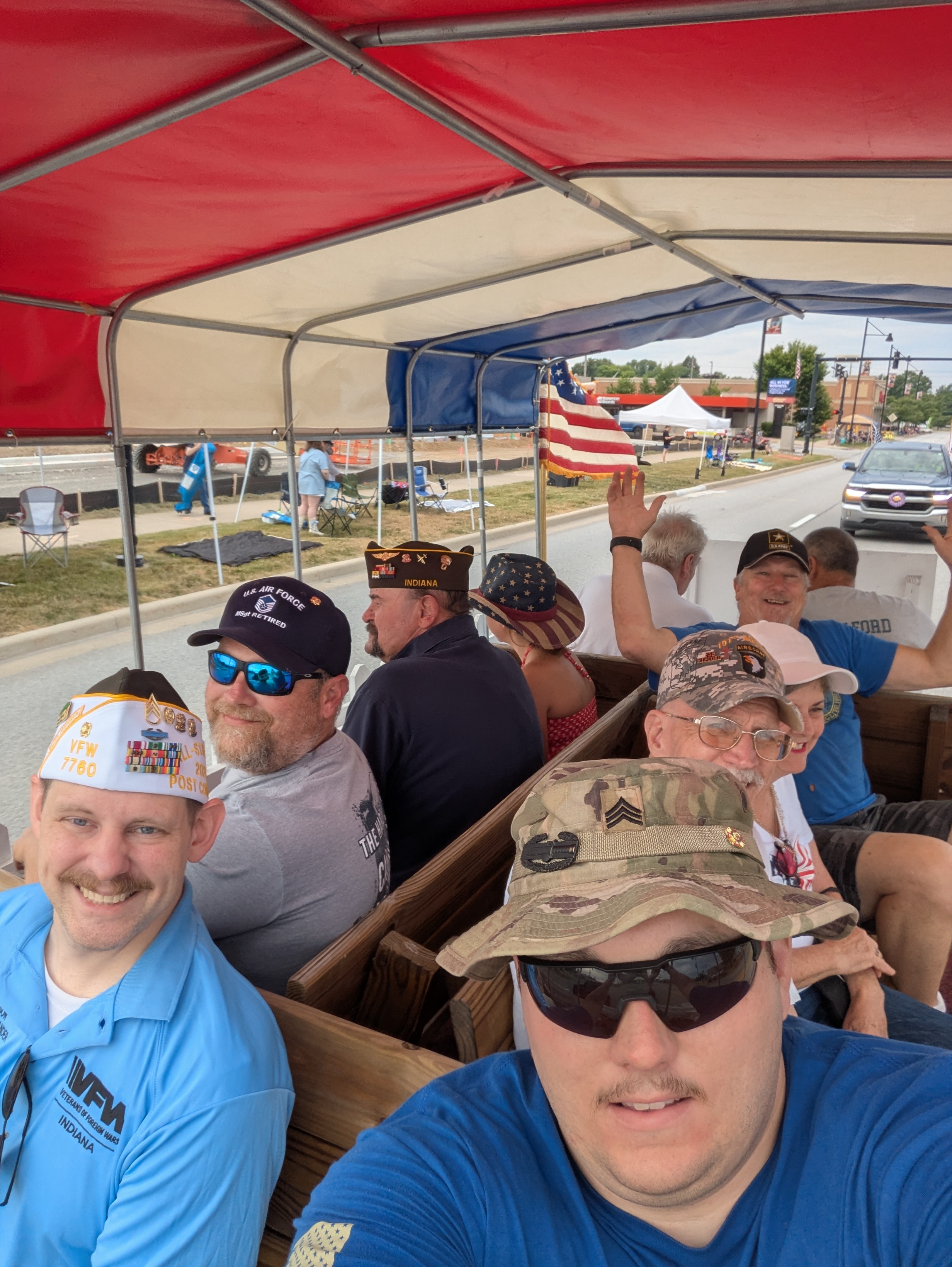 VFW Post 7760 members riding the parade float during the Portage 4th of July parade, including Commander Adam Ferguson in his Post Commander cover